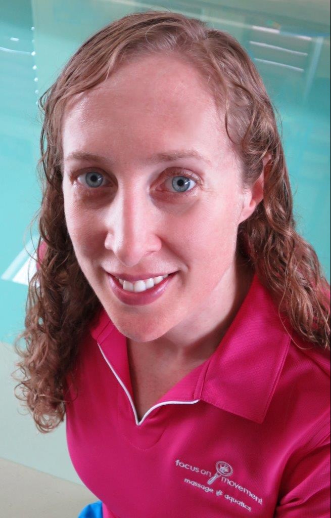 Christine Jervis, Remedial Massage Therapist, smiling, wearing a pink Focus On Movement uniform, in front of her pool at 51 Lyndel Drive, Woree, Cairns, Qld 4868.