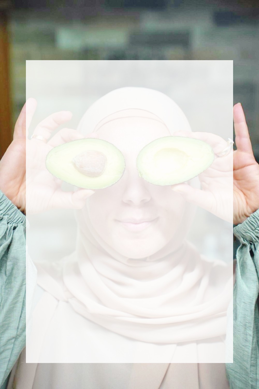 Nutritionist Aesha Haris playfully posing with fresh avocados covering her eyes, reflecting her warm and approachable approach to nutrition at Nourish Health in Casula.